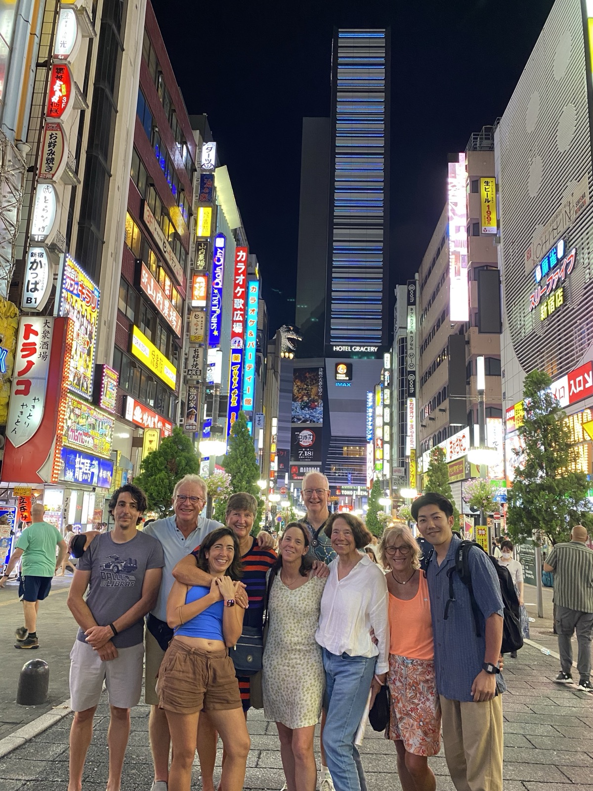 Guests with local guide Yuki on the Full Day Tokyo Seasonal Tour, in front of the Shinjuku skyline at night